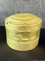 Front view of antique yellow stacking box showing shape and aged patina