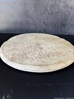 Side profile view showing thickness and slight bevel of the stone cutting board.