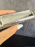 Close-up photo of the metal cover plate of the Hohner Big River Harp harmonica showing engraved branding and numbering on the mouthpiece.