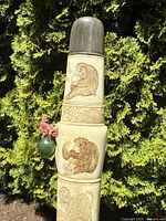 Full view of short sword upright against foliage background