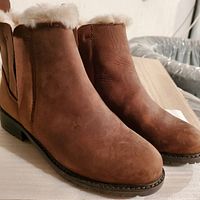 Front-angle view of brown EMU boots showing leather exterior and shearling lining.