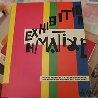 Cover of the Henri Matisse retrospective exhibition book with colorful stripes and abstract text.
