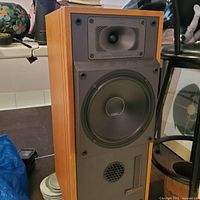 Front view of the mid-century modern speaker showing woofer, horn tweeter, and black front panel with wood casing.