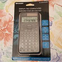 Front view of new and boxed Sharp EL-520XTB-BK advanced scientific calculator, showing model number and key features on packaging.