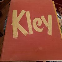 Front cover of the art book with large yellow stylized text 'Kley' on reddish-brown background.