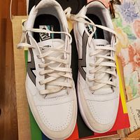 Top view of white VANS sneakers showing laces, toe box, and side logos on both shoes