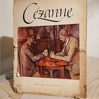 Full view of the cover page showing the title 'Cezanne' and a featured print of two men playing cards at a table. Shows some edge wear and discoloration.