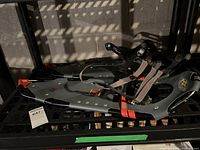 Pair of Atlas 930 snowshoes shown resting on a black grid surface, showing bindings and frame details.