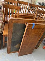 Photo showing underside of wooden bar table and separate leaf extension with wear and some damage.