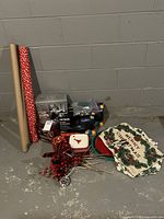 View of Christmas wrapping paper rolls, Noma Christmas string lights boxes, holiday crackers, decorative picks, and fabric runner.