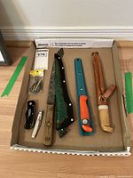 Full lot of fishing cutting utensils and tools in cardboard box.