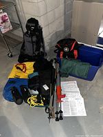 Photo showing all the hiking gear including backpacks, trekking poles, dry bags, rope, maps, and other accessories laid out on the floor