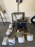 Photo showing all metal and glass lighting fixtures together with visible broken glass shade and metal frames.