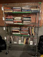 Front view of the metal shelf with books and magazines placed on shelves for reference only, showing shelf structure and condition.