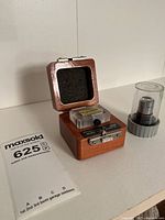 Micro Star diamond knife utensil in open wooden box with foam padding and protective clear cap positioned beside it.