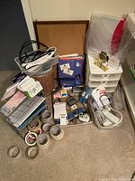 Full view of all office supplies in the lot including the corkboard standing behind, desk clock, baskets, tapes, and other desk supplies scattered