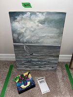 Photo of two paintings together, larger sailboat painting (16x12 inches) and smaller flower painting (4x4 inches) with tags showing dimensions.