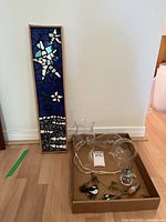 Mosaic art panel and assorted decorative items displayed on floor showing scale and lot contents