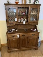 Full view of two-piece buffet and hutch showing overall design and condition with some display items inside.