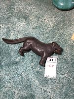 Front side view of the cast iron dog shaped nutcracker showing textured fur details and the lever behind the dog body.