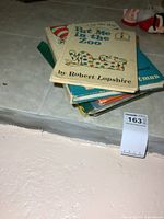 Stack of vintage children's books showing top book as 'Put Me in the Zoo' by Robert Lopshire.