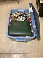 Large blue plastic bin filled with a vast quantity of assorted vintage matchbooks and matchbook covers, including loose ones and albums.
