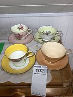 Photo showing all four Paragon teacups with their matching saucers on a wooden table.