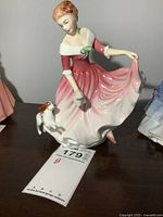 Front and side views of Royal Doulton figurine showing a young woman in a pink and white dress with a small dog.