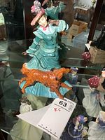 Front view of Royal Doulton Autumn Time figurine showing woman in teal dress with orange-brown dog at feet