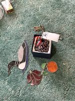 Photo showing the stained glass loon, angel, orange pieces, glass ball in box, and dragonfly chime on carpeted floor