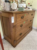Side and front view of antique wooden dresser showing wood grain and metal handles.