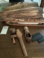 Overview of antique wooden weaving shuttles, wooden mallets, thread holder, and other tools on wood surface