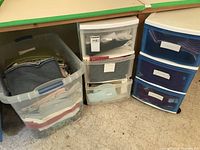 Long plastic storage container filled with assorted folded fabric remnants of various colors and patterns.