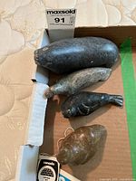 Overhead view of all four stone seal carvings in cardboard box