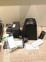 Photo showing JBL SB300 subwoofer, D-Link DSL-520B modem, small black speakers, white wireless keyboards, and a Westinghouse speaker.