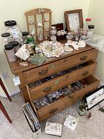 Wide view of the dresser top and drawers with seashell jars, bags, and decorative items on and inside drawers.