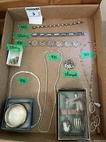 Overview of assorted silver bracelets, necklaces, earrings, pendant and boxed flatware