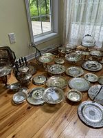 Wide view of the entire collection including tea pot, plates, candlesticks, and accessories on the floor near a window