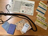 Wide view of the vintage documents including ration books, tax stamp, and leather whip