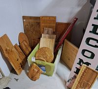Assortment of handcrafted wood carvings of various sizes gathered in a corner including plaques and decorative signs.