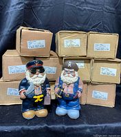 Photo shows eleven new pirate banks in box packaging behind two different styles of pirate banks, standing approximately 7.5 inches tall.