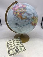 World globe displayed with six US $2 bills in front, showing the full lot composition.