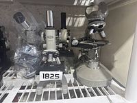 Four microscopes arranged on a shelf including Olympus and Parco Scientific models