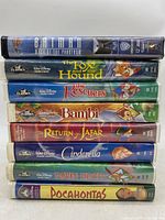 Stack of 9 VHS tapes showing spines with titles including 8 classic Disney movies and one Batman movie.