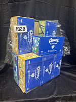Nine unopened boxes of Kleenex Trusted Care facial tissues stacked and shrink-wrapped