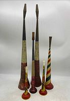 Overall view of all six tin horn noisemakers in varying sizes and color patterns