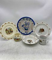 Full set arranged showing Bunnykins plates, bowls, mugs, and handpainted plate with blue border and horse rider design