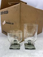 Two glasses showing clear bowl with smokey grey stem and square base, vintage Federal Glass stemware with original box