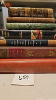 Stack of seven vintage books with visible titles and spines