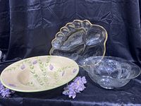 Three serving bowls arranged: large ceramic bowl with lavender design, vintage divided glass platter with gold trim, and smaller clear textured glass bowl.